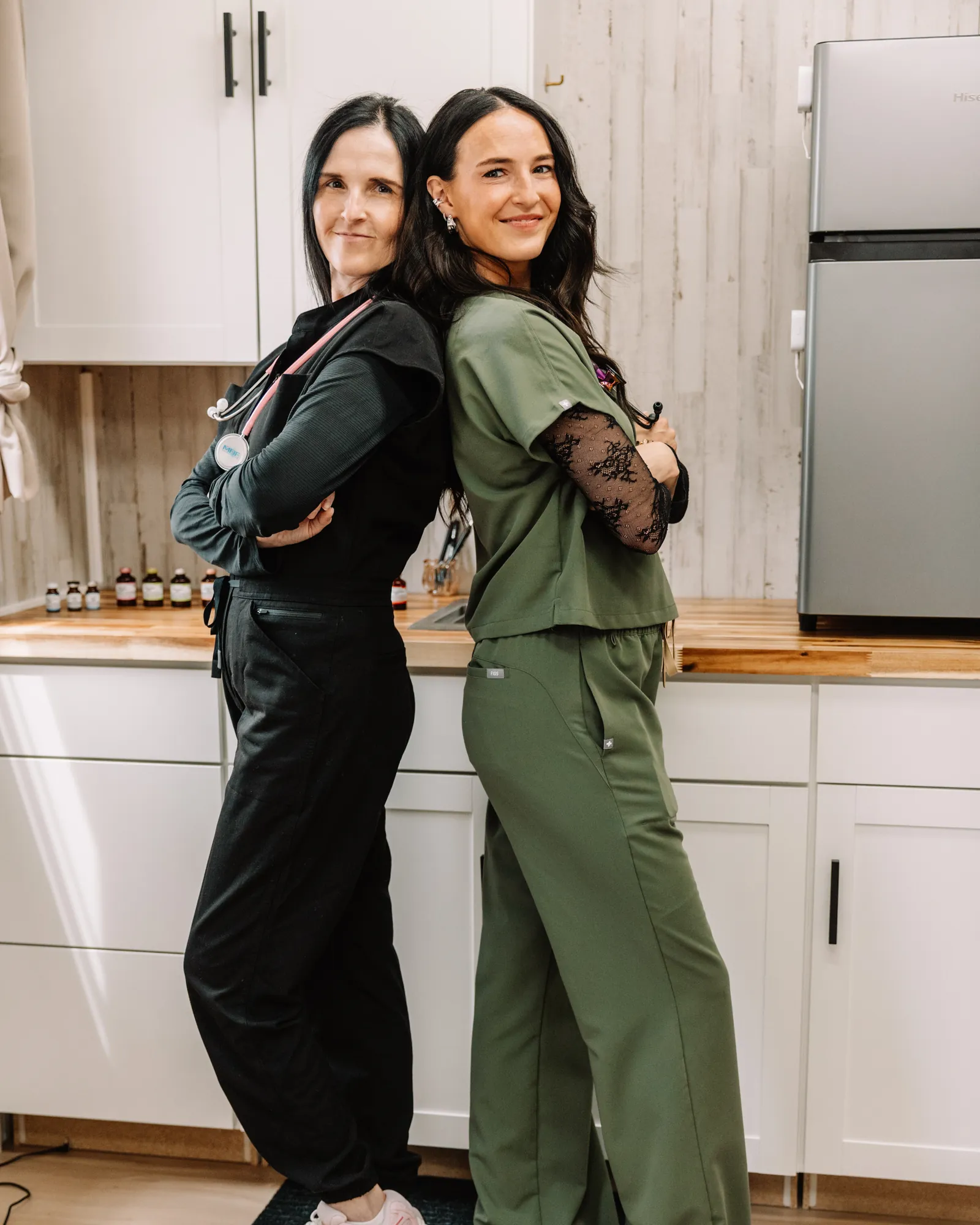 Jaedee and Melissa standing back-to-back in the Jaed Aesthetics studio