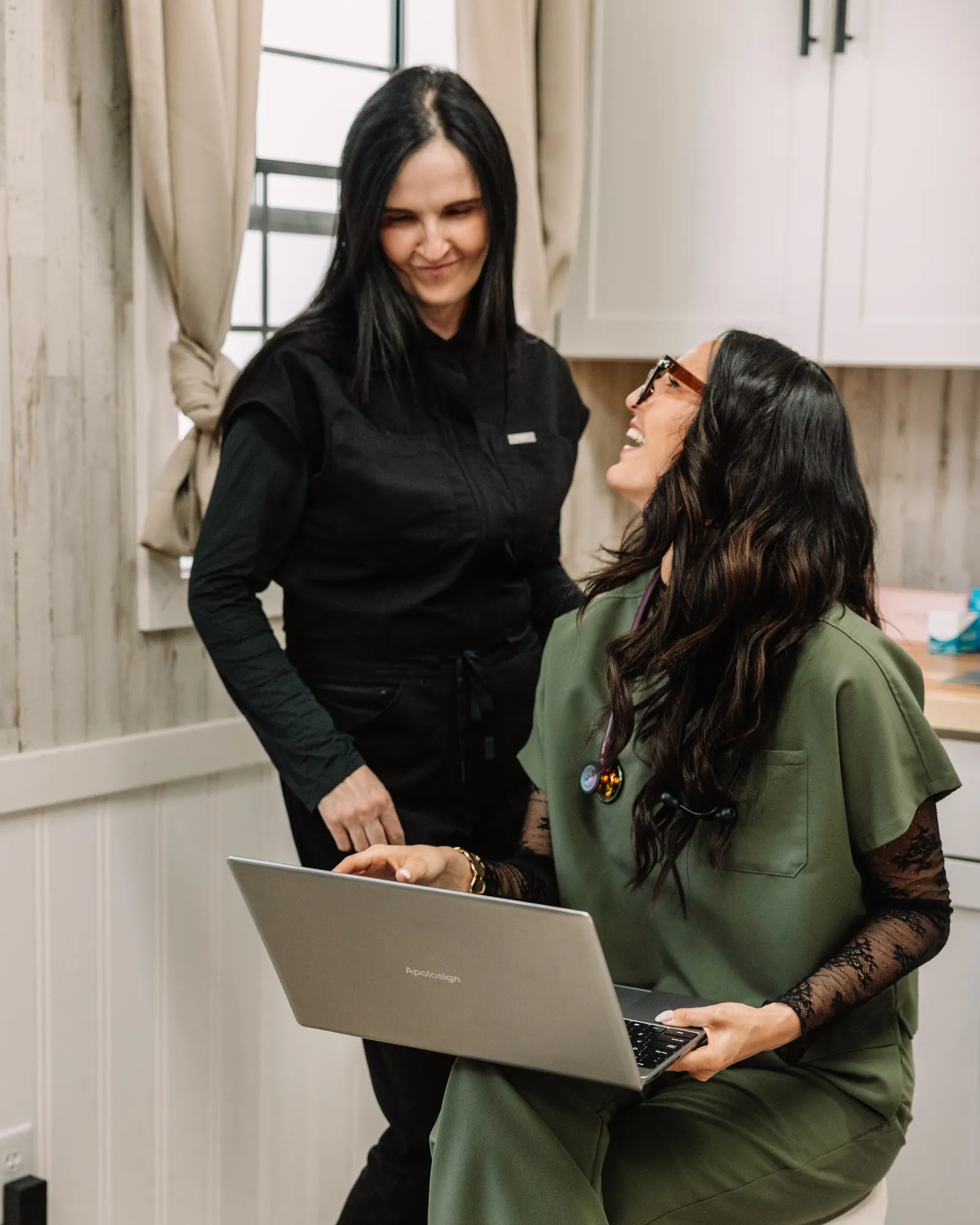 Melissa and Jaedee reviewing a treatment plan together on a laptop in the studio
