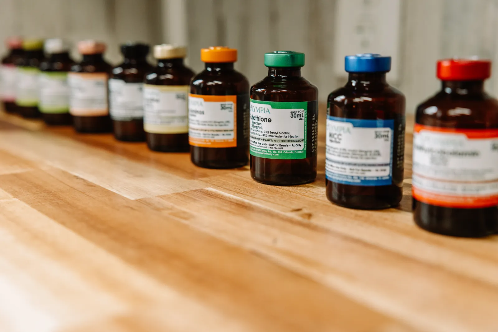 A row of vitamin and amino-acid vials lined up on the studio counter