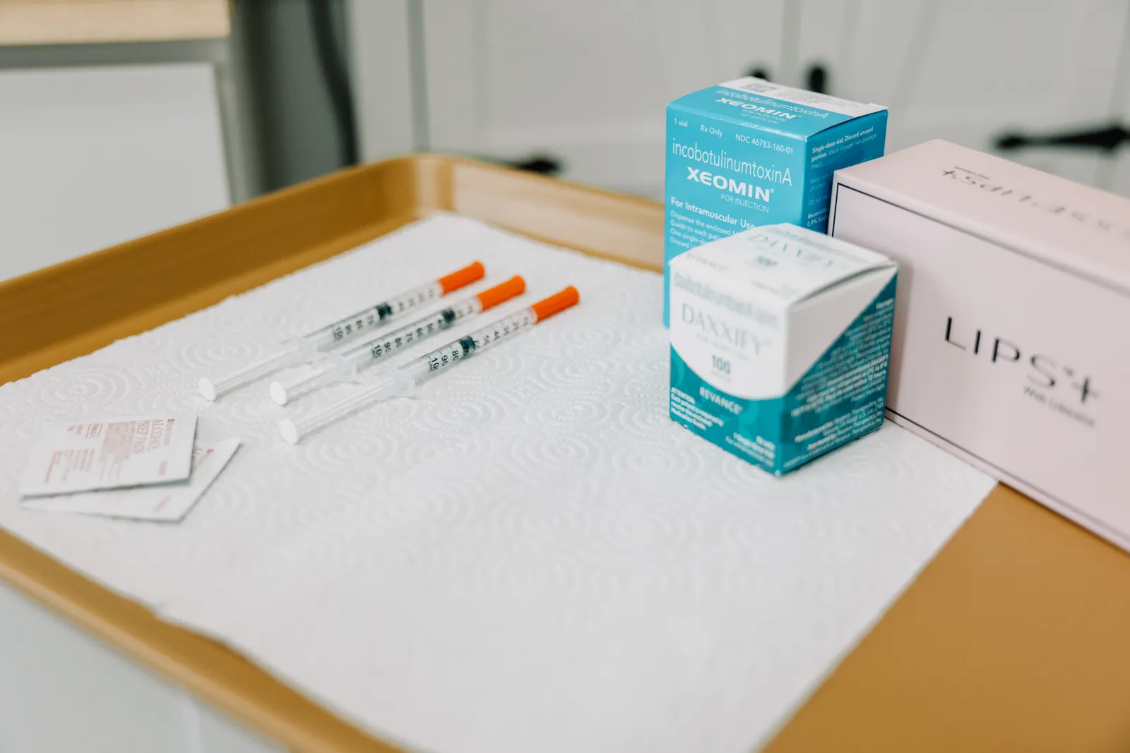 Filler syringes and product boxes arranged on a gold tray