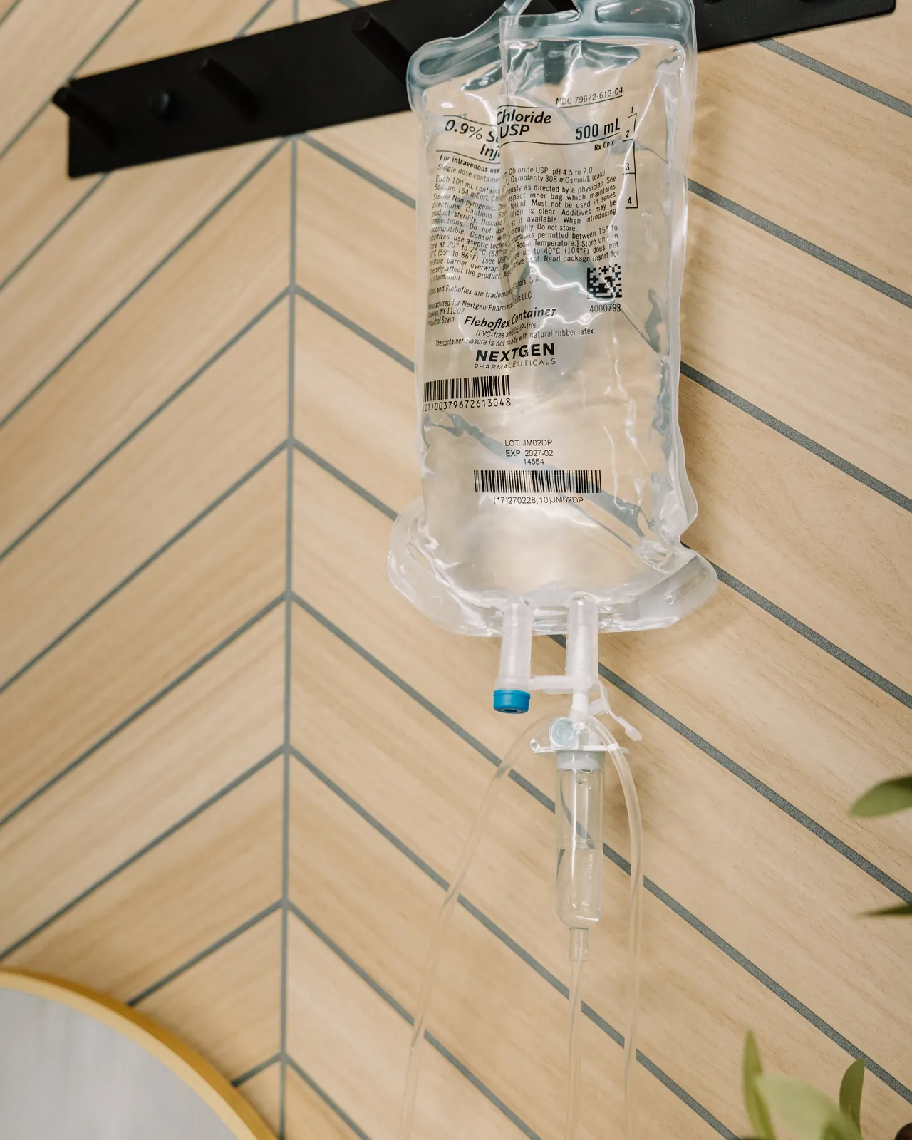 An IV drip bag hanging against the studio's chevron wood wall